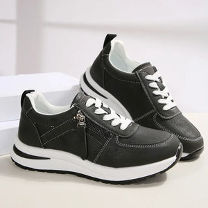 Black sneakers with white soles on a light background