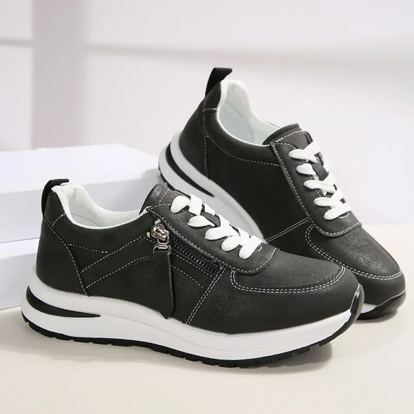 Black sneakers with white soles on a light background