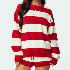 Red and white striped sweater worn by a person on a plain background