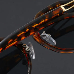 Close-up of tortoiseshell sunglasses with gold accents on a dark background