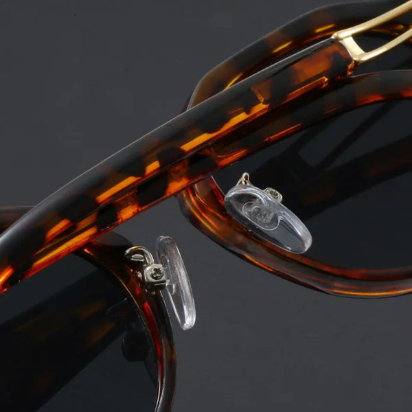 Close-up of tortoiseshell sunglasses with gold accents on a dark background