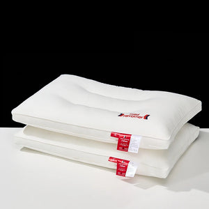 Two white pillows with red labels on a white surface