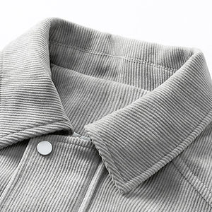 Close-up of a gray corduroy jacket with a collar and button detail.