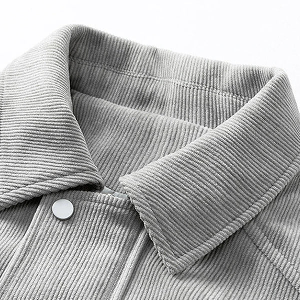 Close-up of a gray corduroy jacket with a collar and button detail.