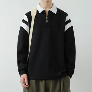 Person wearing a black sweater with white stripes on a plain background