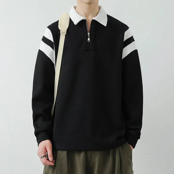 Person wearing a black sweater with white stripes on a plain background