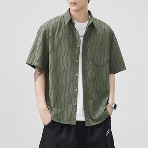 Person wearing a green textured shirt over a white t-shirt on a plain background