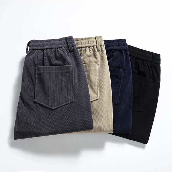 Four pairs of pants in different colors arranged on a light gray background