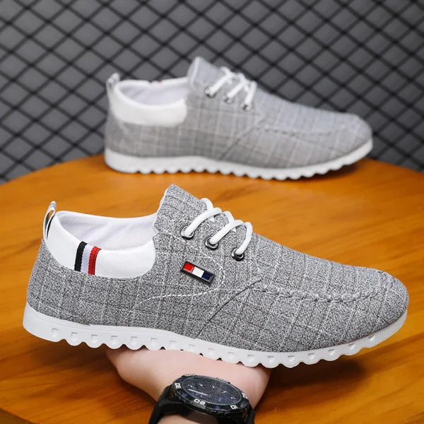 Gray casual shoes with white soles on a wooden surface