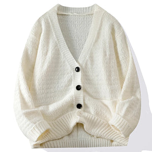 White knitted cardigan with black buttons on a white background