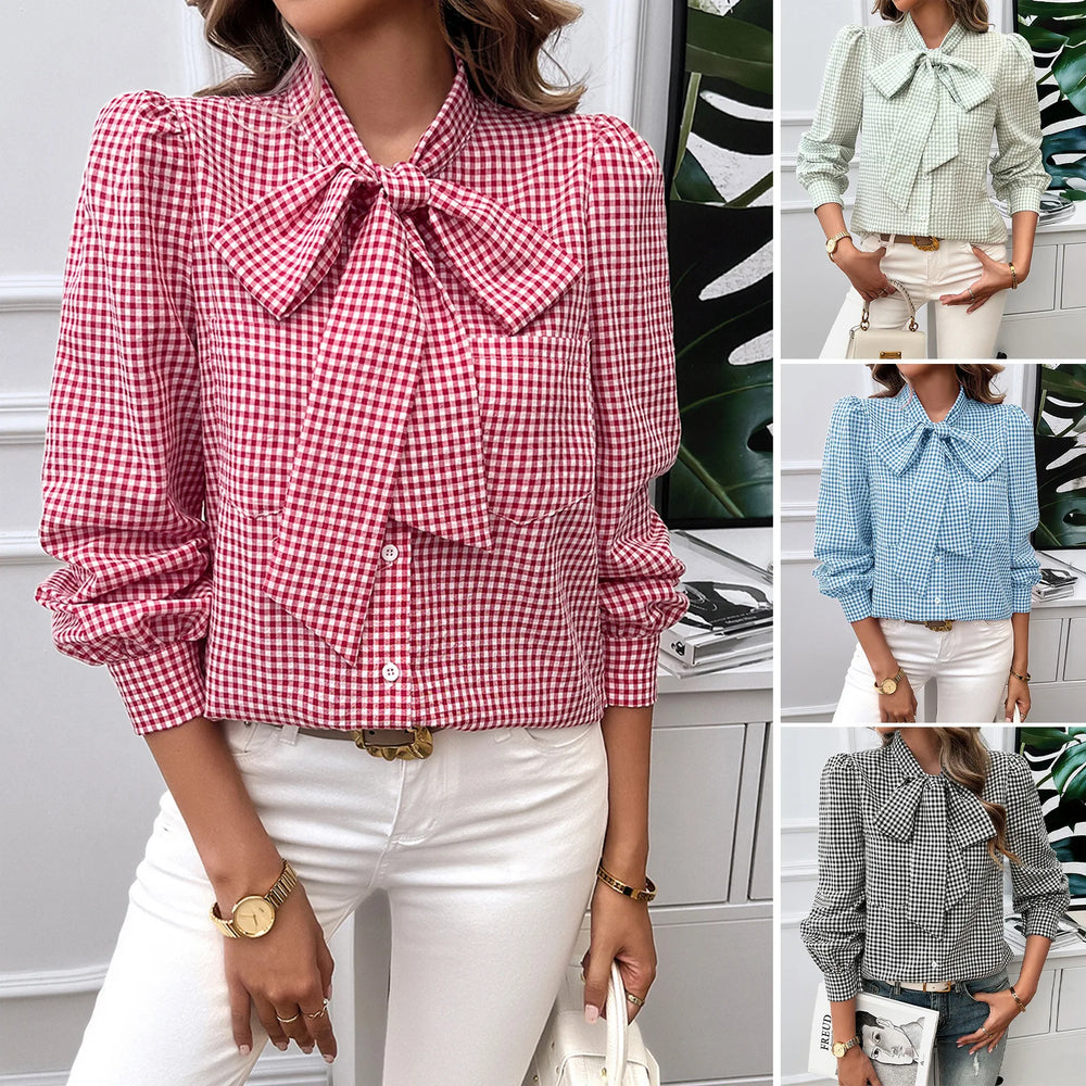 Woman wearing a green checkered blouse with a bow tie, holding a beige handbag.