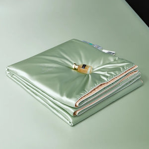 Folded green blanket with a bottle on a light green background
