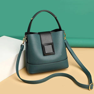 Green handbag with a black strap on a beige and green background