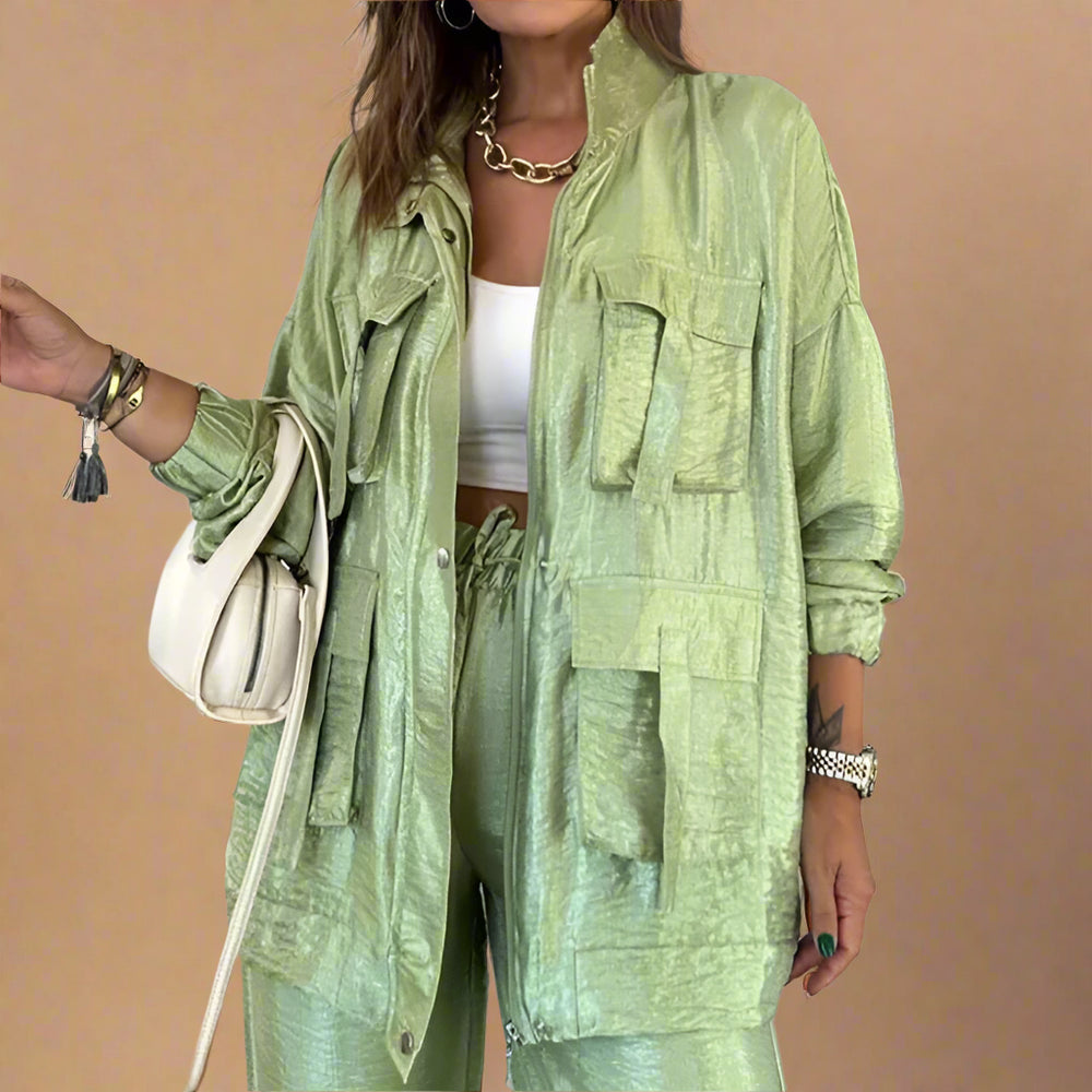 Person wearing a green outfit with a jacket and pants in an indoor setting.