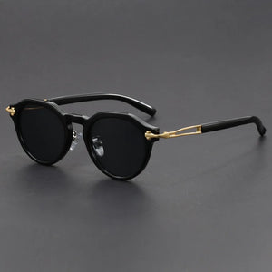 Black sunglasses with gold accents on a dark gray background