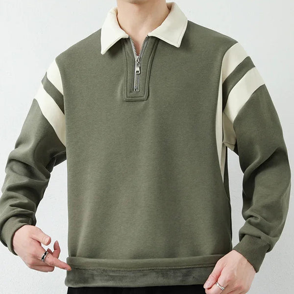 Person wearing a green and white zip-up sweatshirt on a plain background