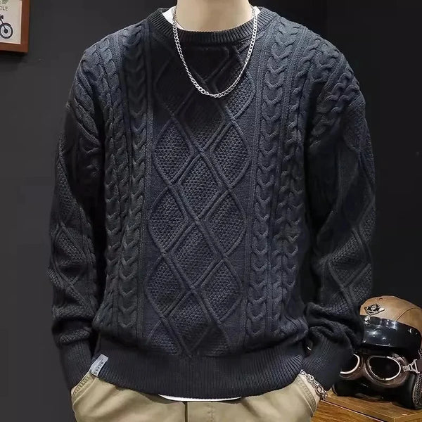 Dark blue cable knit sweater worn by a mannequin on a dark background