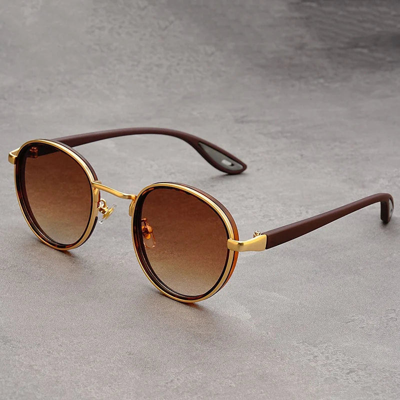 A pair of sunglasses with a vintage-inspired round frame and UV protection lenses, displayed on a white stand.
