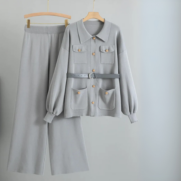 Gray outfit with jacket and pants on hangers against a light gray background