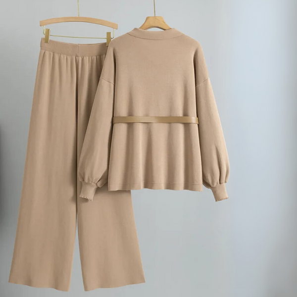 Beige outfit with long-sleeve top and wide-leg pants on hangers against a light gray background