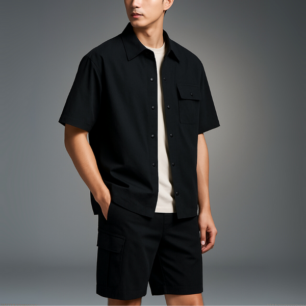 Person wearing a black short-sleeve shirt and black shorts on a gray background