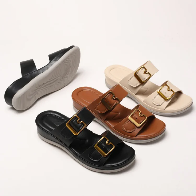 Four pairs of sandals in black, brown, and beige with gold buckles on a white background.