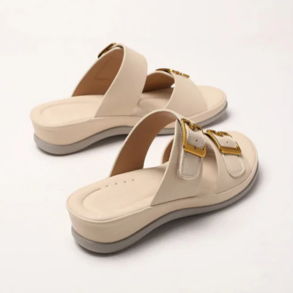 Beige sandals with gold buckles on a white background