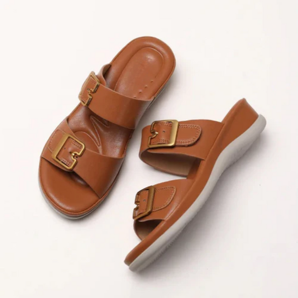 Pair of brown sandals with gold buckles on a white background