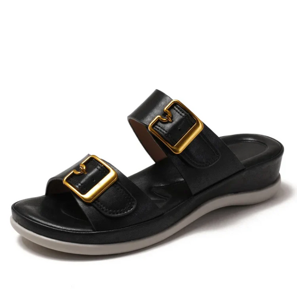 Black sandal with gold buckles on a white background