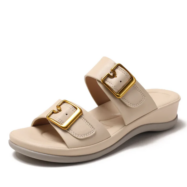 Beige sandal with gold buckles on a white background